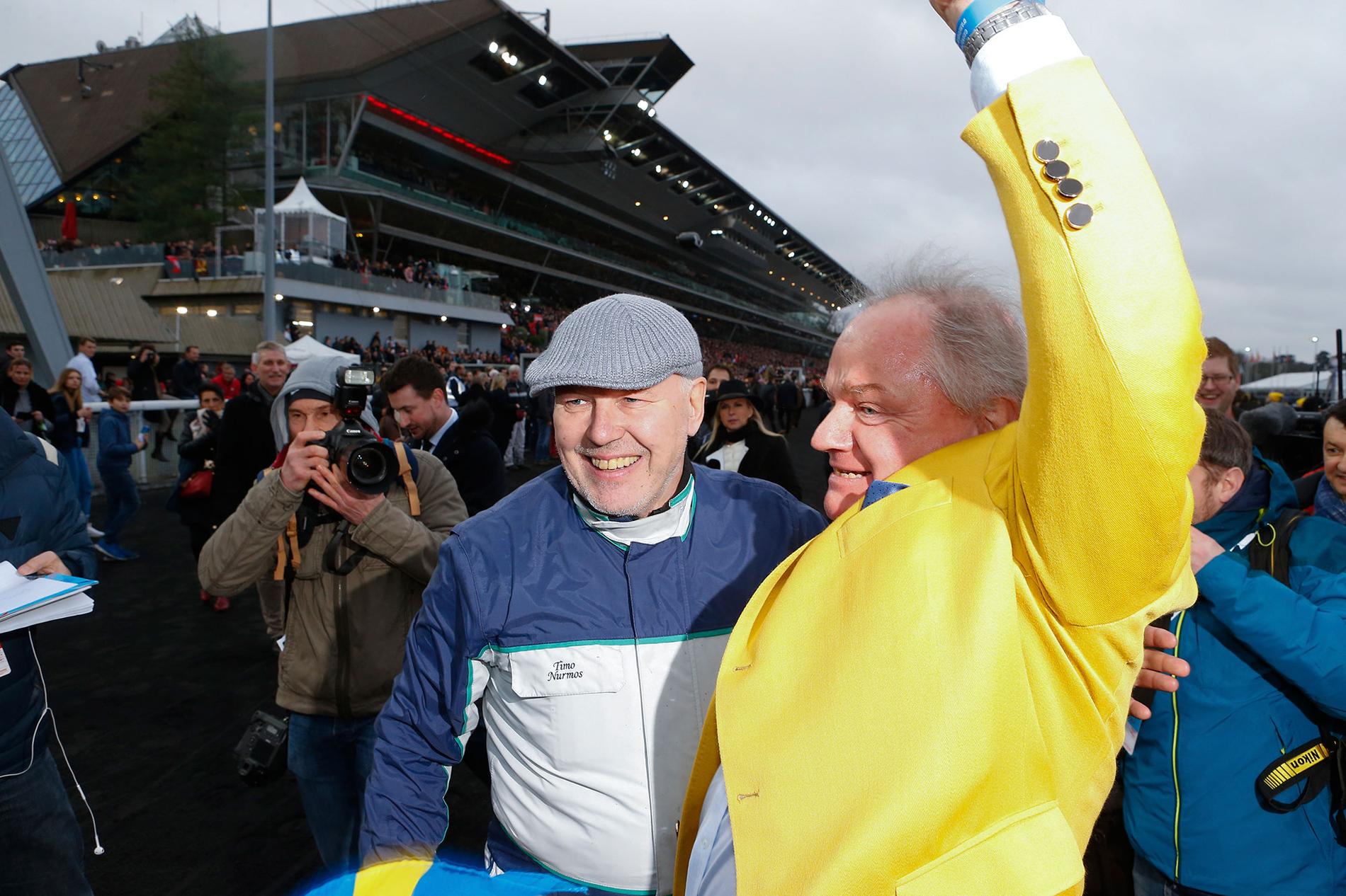Readly Express ägaren Rolf Andersson i gul kavaj och tränaren Timo Nurmos jublar efter segern i Prix d’Amérique 2018. Nu siktas hästen mot Elitloppet.