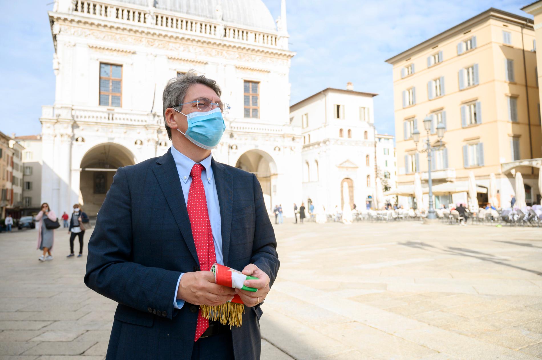 Borgmästaren i Brescia, Emilio Del Bono, framför Palazzo della Loggia där han har sitt kontor. I handen håller han borgmästarebandet.