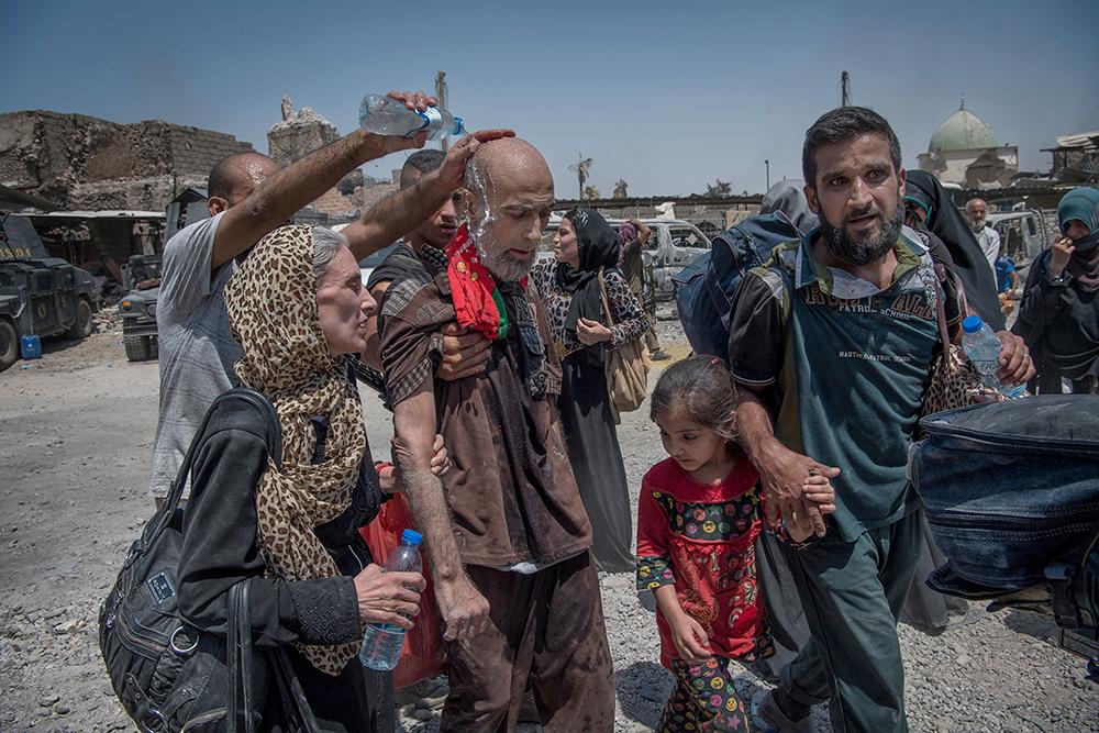 De människor som kommer ut ur gränderna i Mosuls gamla stad är utmattade av den 44-gradiga hettan. De berättar att de varken ätit eller druckit på flera dagar.