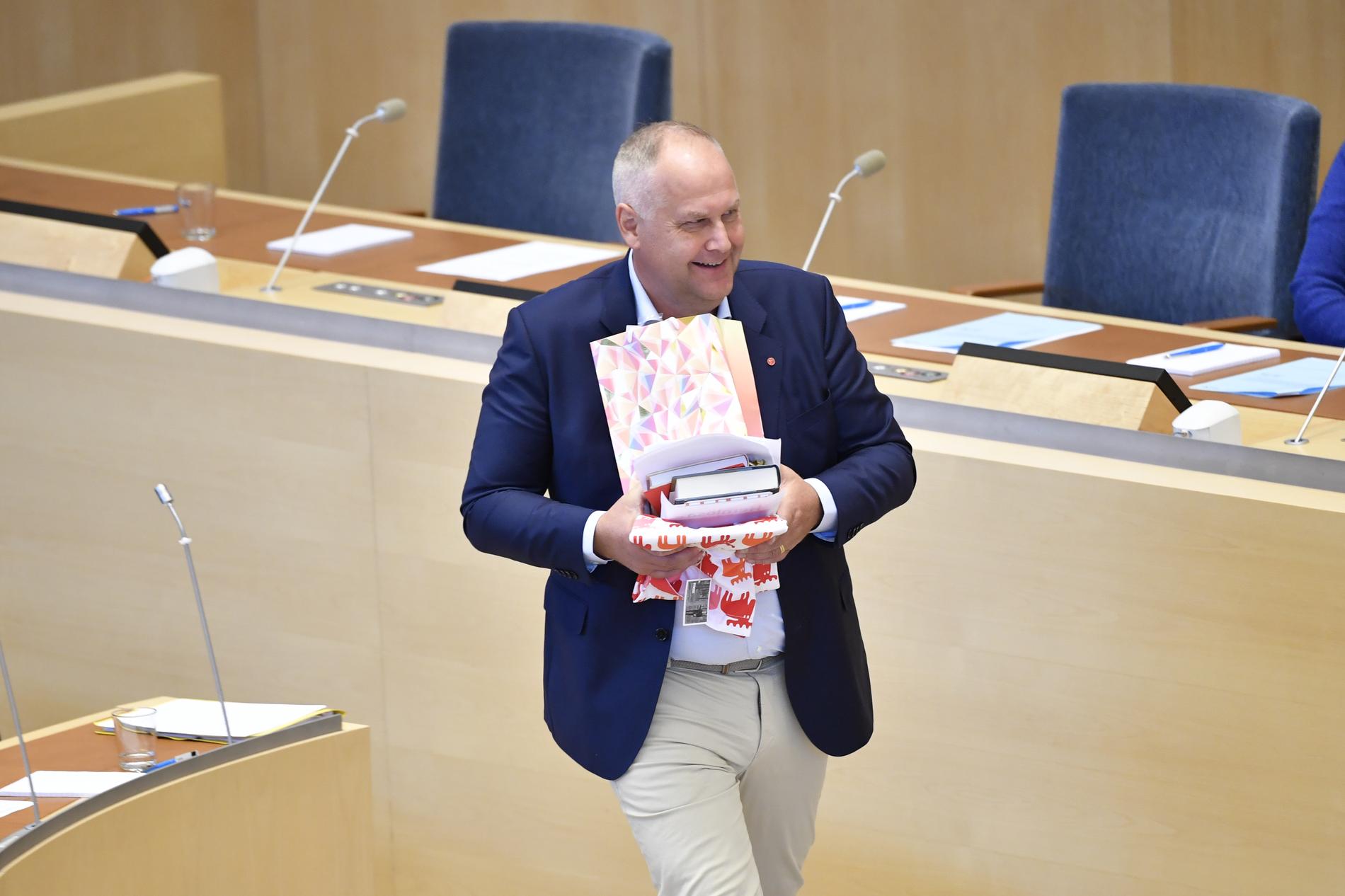 Jonas Sjöstedt (V) med sina avtackningspresenter vid riksdagsårets första partiledardebatt i riksdagen