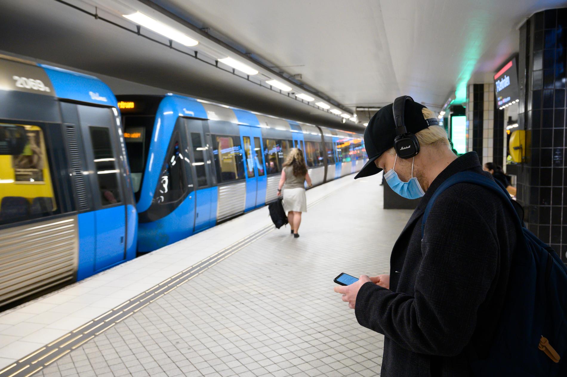 En man bär munskydd i Stockholms tunnelbana