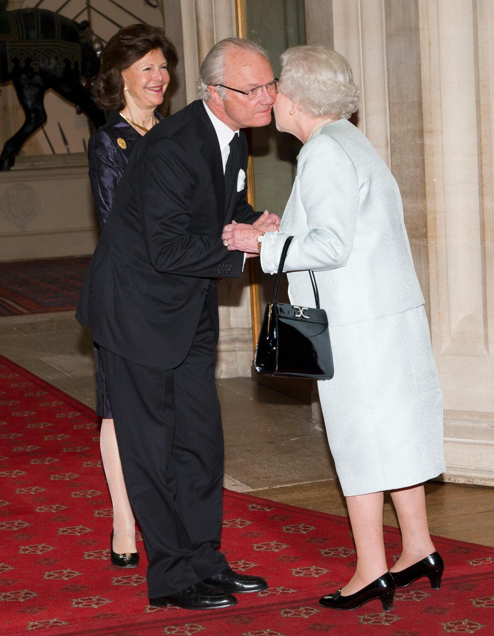 Carl XVI Gustaf och drottning Silvia hälsar på den brittiska drottningen. 