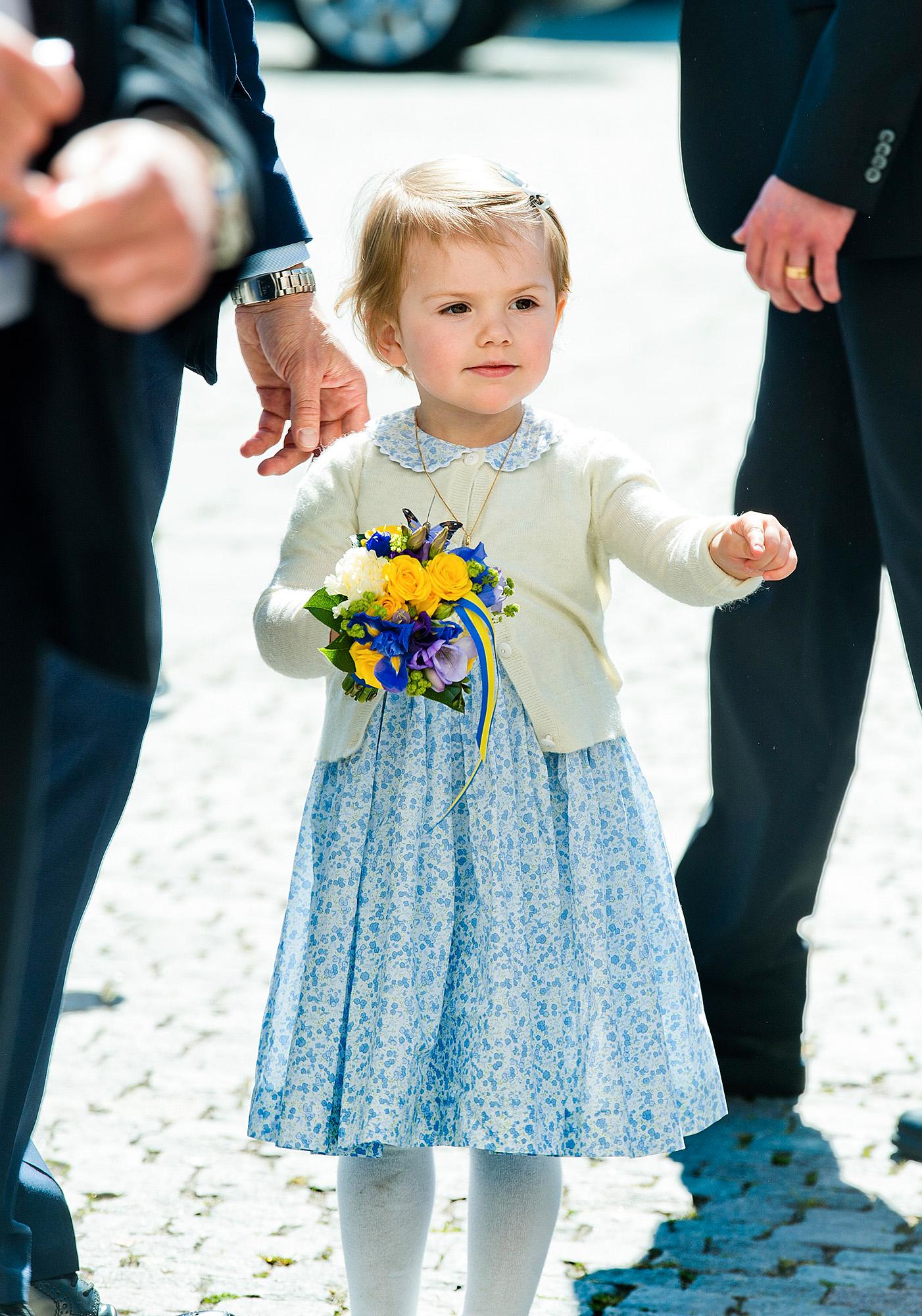 Prinsessan gör sitt första officella uppdrag tillsammans med mamma Victoria och pappa Daniel klädd i blåblommig klänning matchat med citrongul kofta.