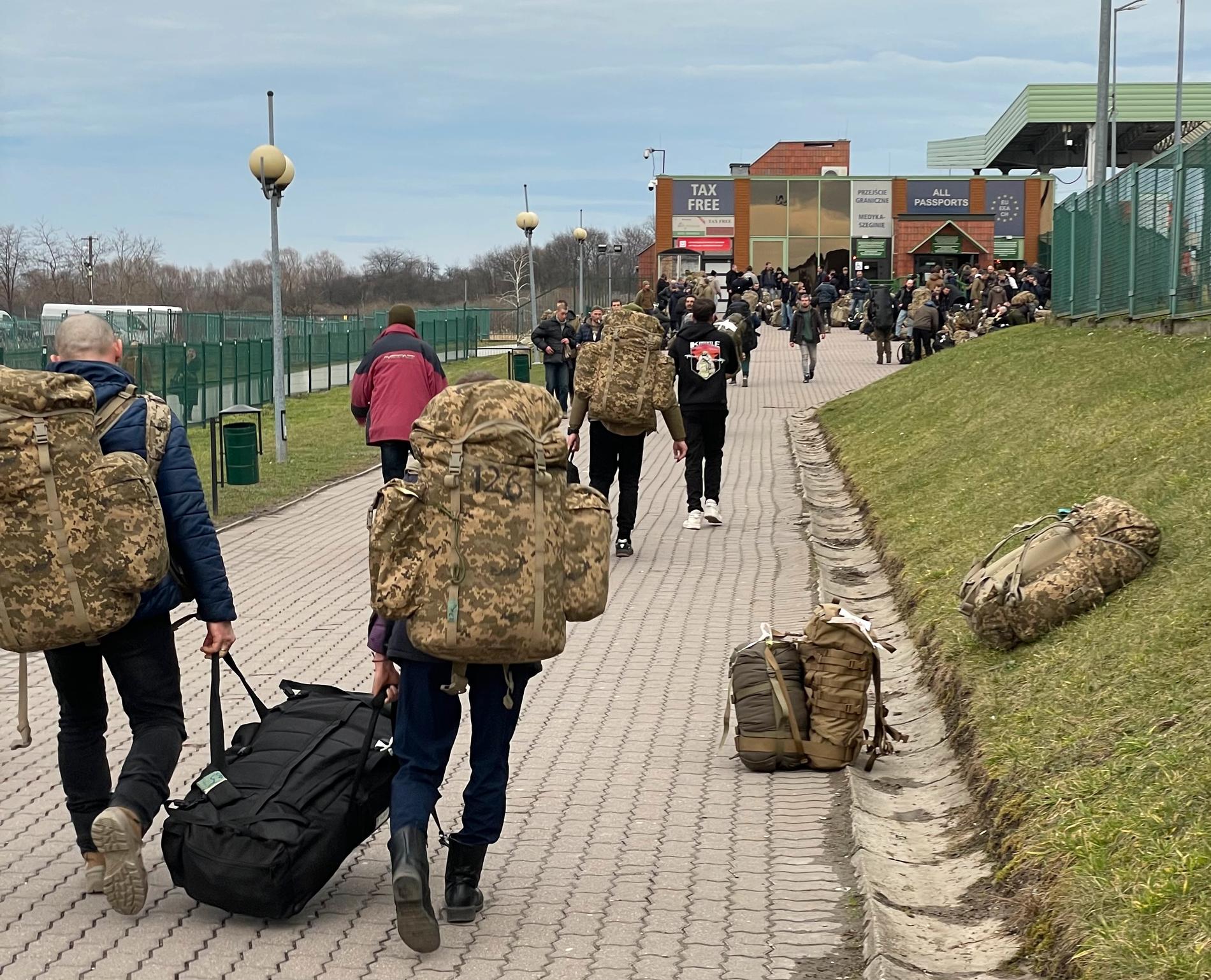 Ukrainska soldater på väg genom gränskontrollen och tillbaka mot fronten.