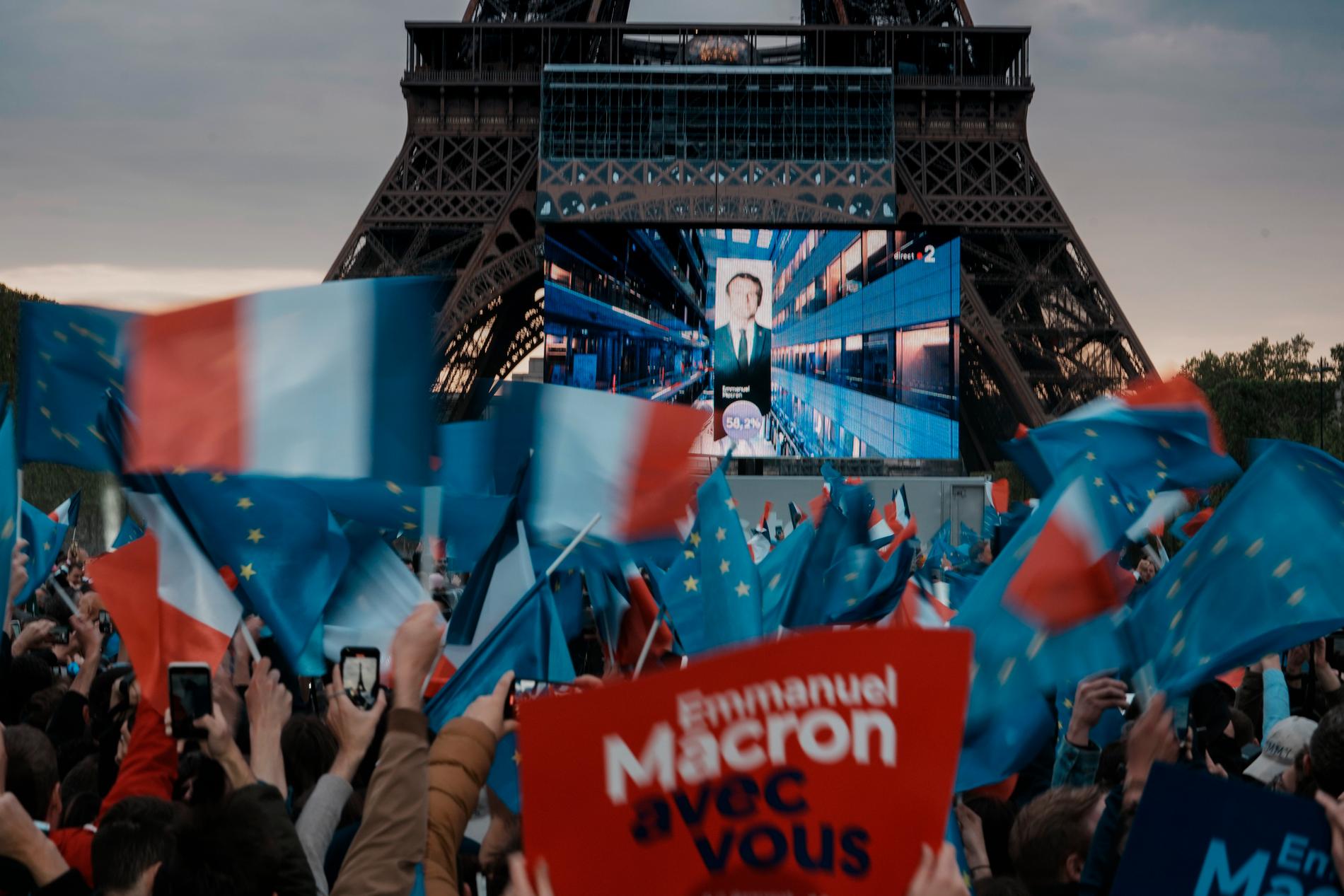Emmanuel Macrons väljare reagerar när hans bild dyker upp och han presenteras som vinnare av valet, vid valvakan vid Eiffeltornet.