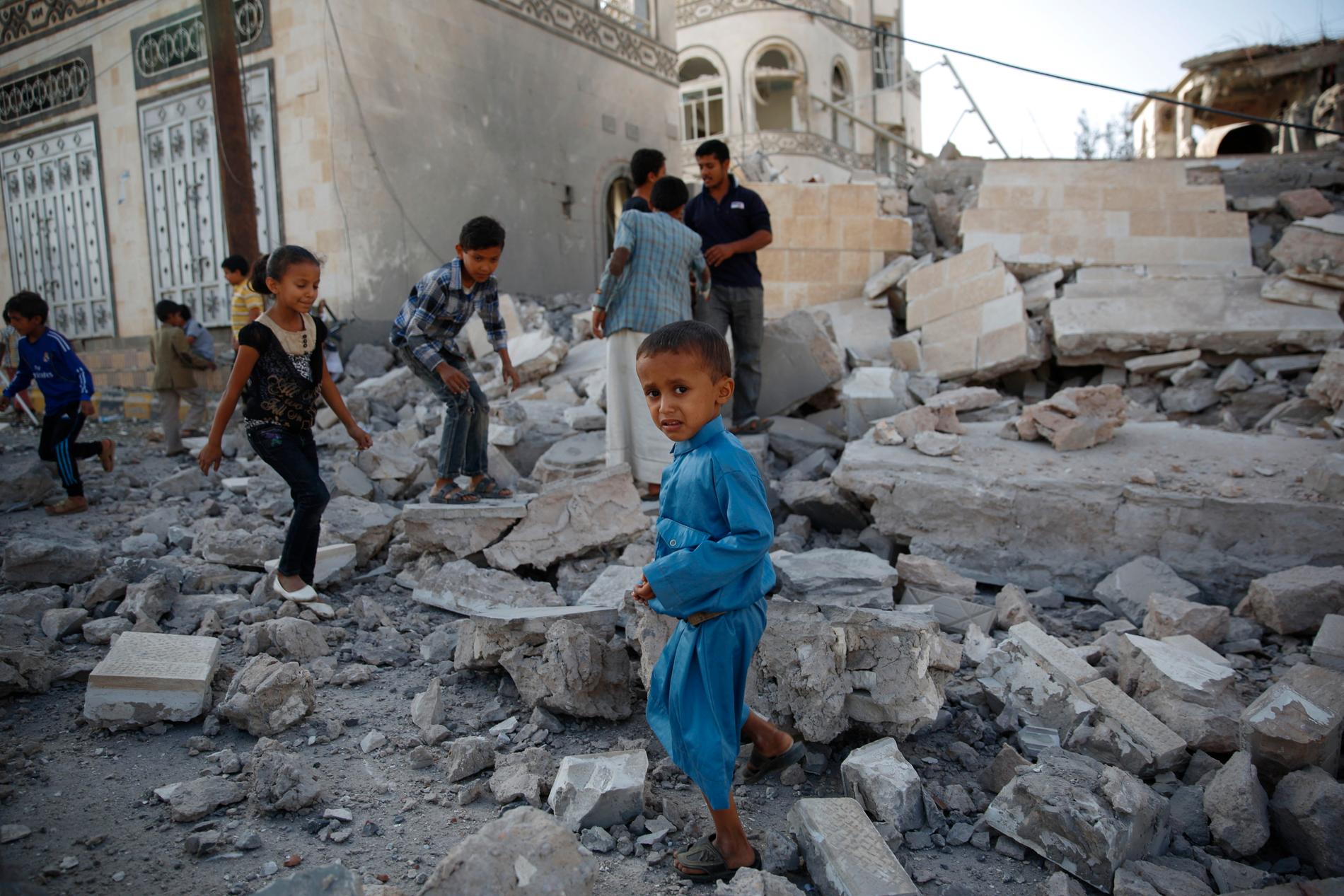 Barnen leker i spillrorna av ett söndersprängt hus i Sanaa, Jemen.  